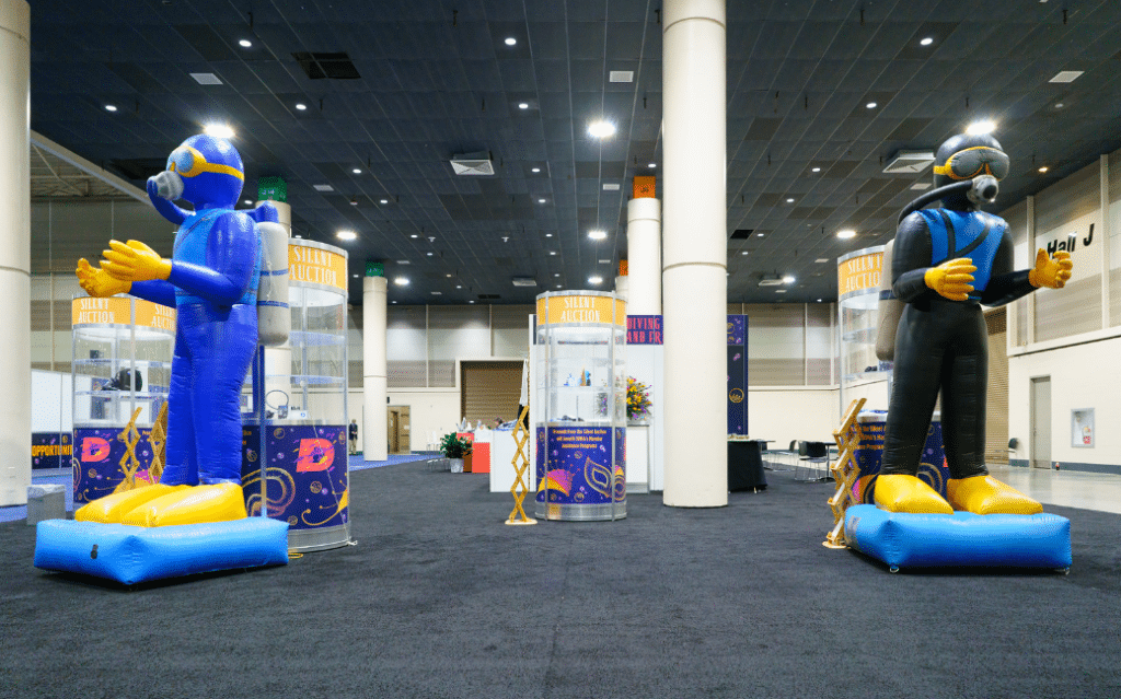 Decorations At A Previous Diving Equipment &Amp; Marketing Association - Dema Show With Inflated Scuba Divers. 