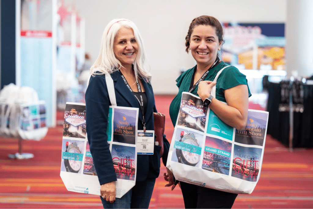 Two Attendants With Bags Smiling At A Previous Las Vegas Souvenir &Amp; Resort Gift Show.